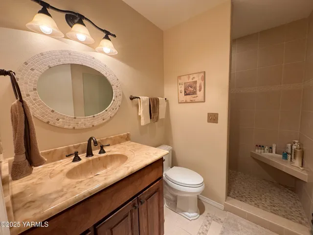 a bathroom with a granite countertop toilet a sink and mirror
