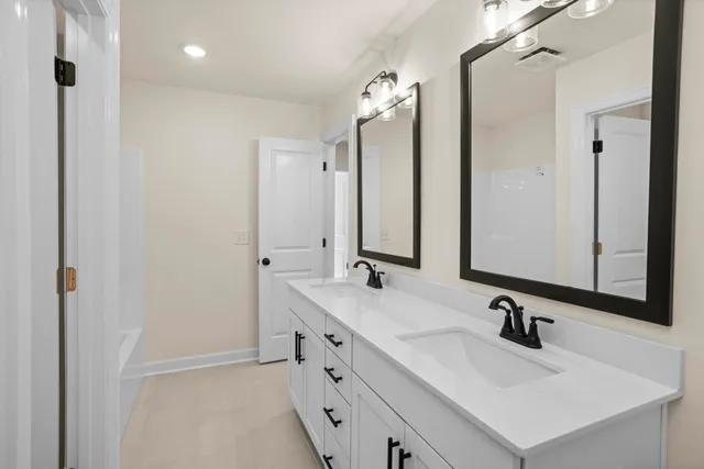 a bathroom with a sink vanity tub and a mirror