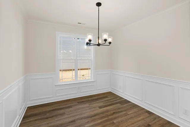 a view of a room with wooden floor chandelier and window