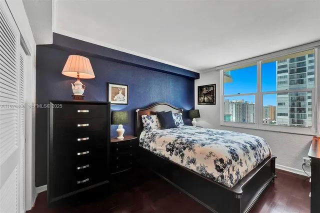 a bedroom with a bed and a potted plant on the dresser