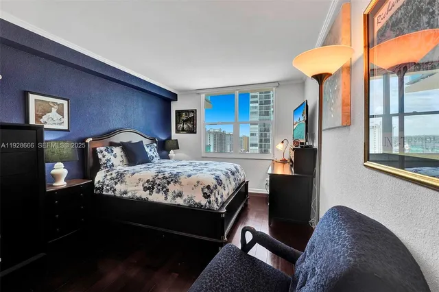 a bedroom with a bed window and a flat screen tv