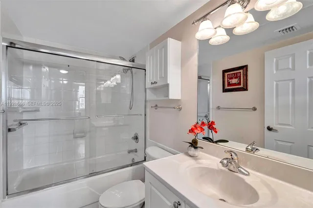 a bedroom with a bed and a dresser with wooden floor