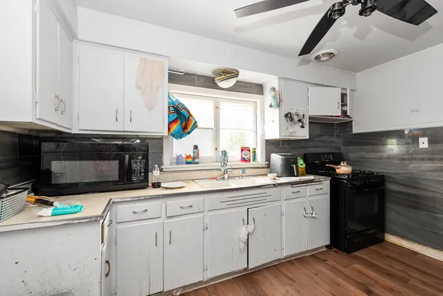 a kitchen with stainless steel appliances granite countertop a sink a stove and cabinets