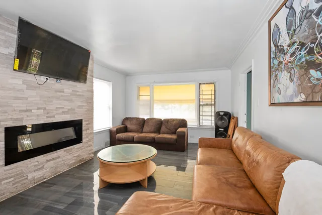 a living room with furniture a flat screen tv and a fireplace