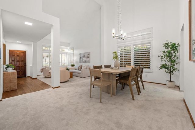 a view of a dining room with furniture and a chandelier