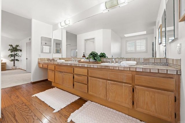 a bathroom with a double vanity sink a toilet a mirror and shower