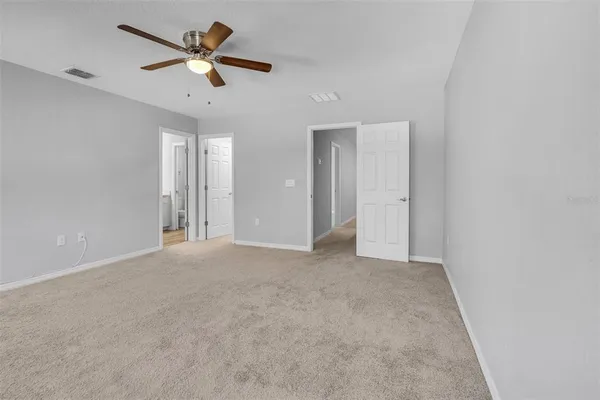 an empty room with ceiling fan and window