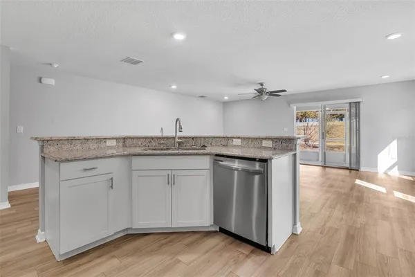 a kitchen with stainless steel appliances granite countertop a stove and a wooden floors