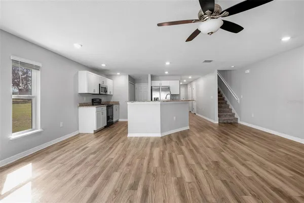 a view of kitchen with sink microwave refrigerator and cabinets