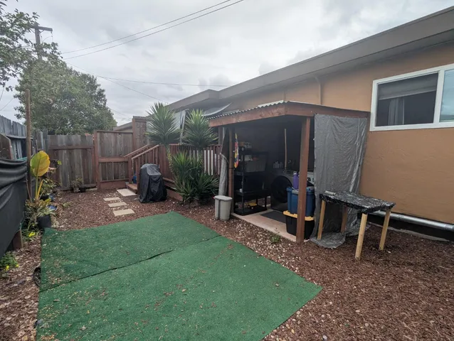 a view of a backyard with table and chairs and wooden fence