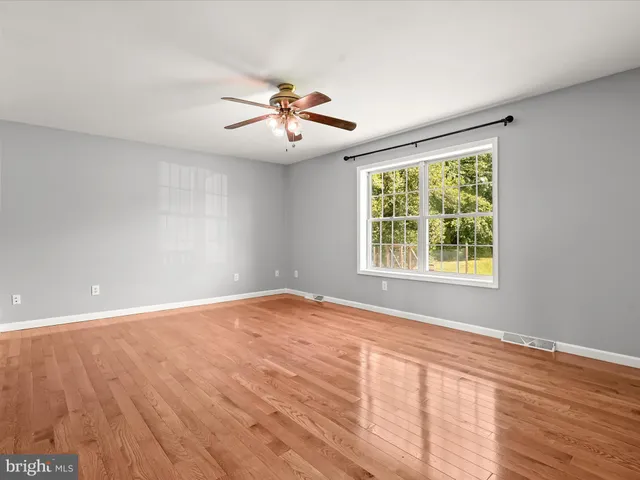 a view of a room with wooden floor and large windows