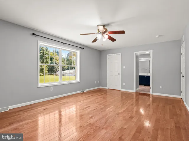 a view of a house with a yard and a large tree
