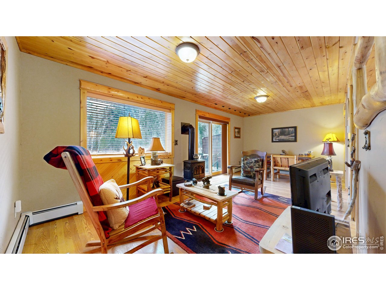 1280 Fall River Road, Unit 1 Estes Park, CO 80517 - Photo 5 of 29 Cozy living room with gas stove for perfect ambiance while you listen to the river