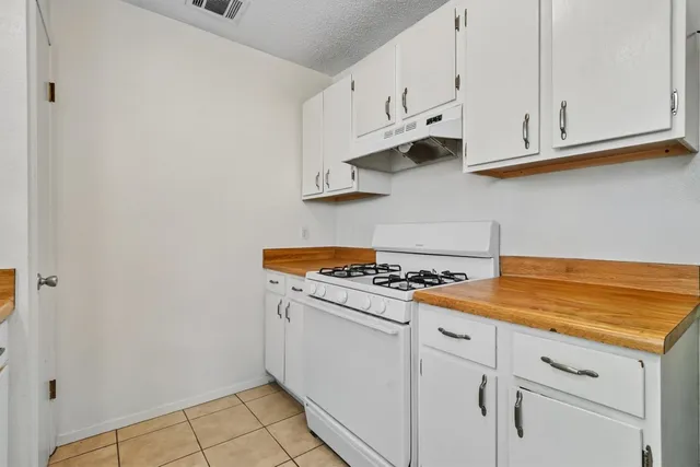 a kitchen with white cabinets and white appliances