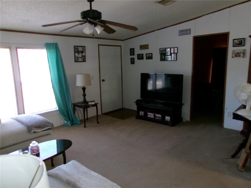 12525 Southeast 83rd Terrace Belleview, FL 34420 - Photo 33 of 47 a living room with furniture and a flat screen tv