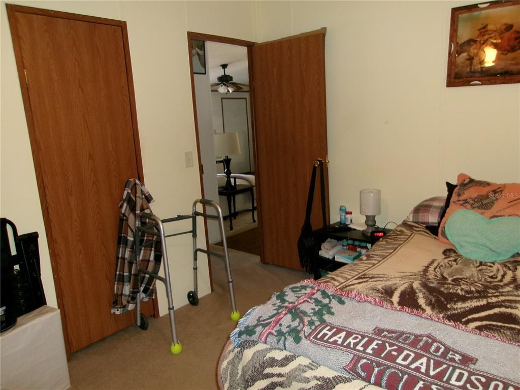 12525 Southeast 83rd Terrace Belleview, FL 34420 - Photo 47 of 47 a bedroom with a bed and a flat tv screen on the dresser
