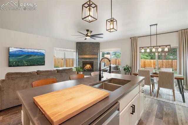 a kitchen with stainless steel appliances granite countertop a sink a stove and a wooden floors