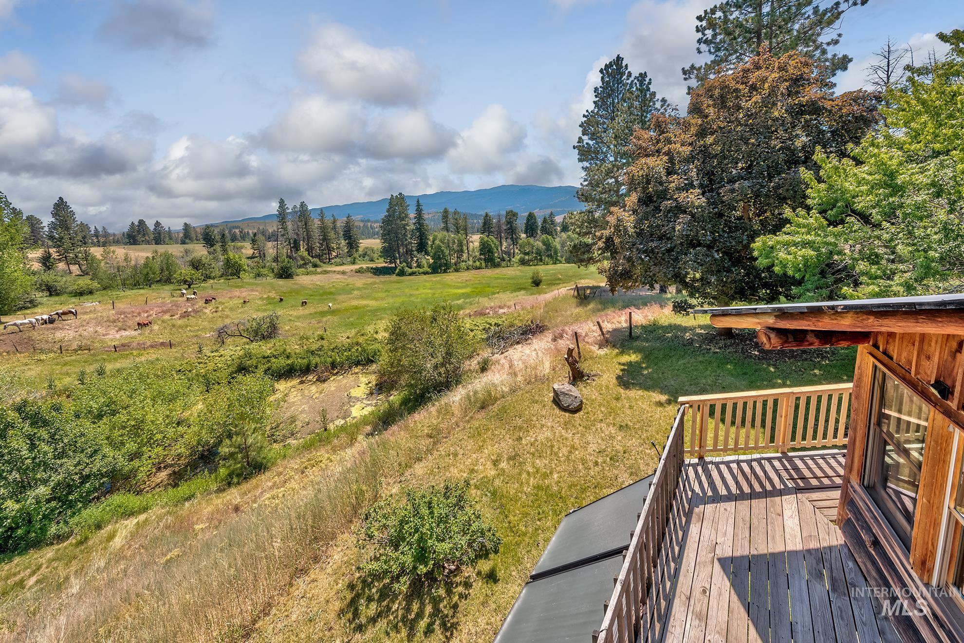 2150 Seid Creek Road Cambridge, ID 83610 - Photo 22 of 50 Spacious outdoor deck with natural wood railing and flooring, offering expansive views of rolling hills and distant mountains