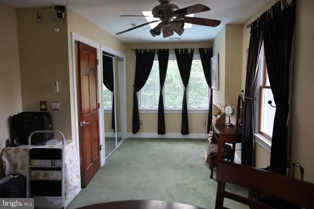 a bedroom with a bed and large windows