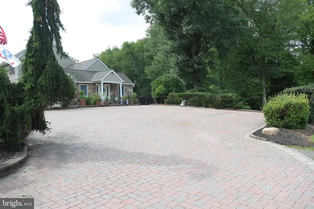 a front view of a house with a yard and trees