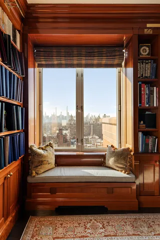 a living room with furniture a bookshelf and a window