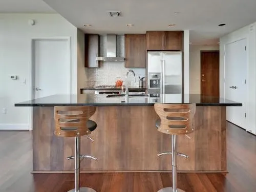 a kitchen with kitchen island granite countertop a refrigerator a stove and a sink with wooden floor