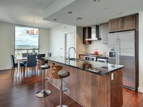 a kitchen with stainless steel appliances granite countertop a sink a stove and a refrigerator