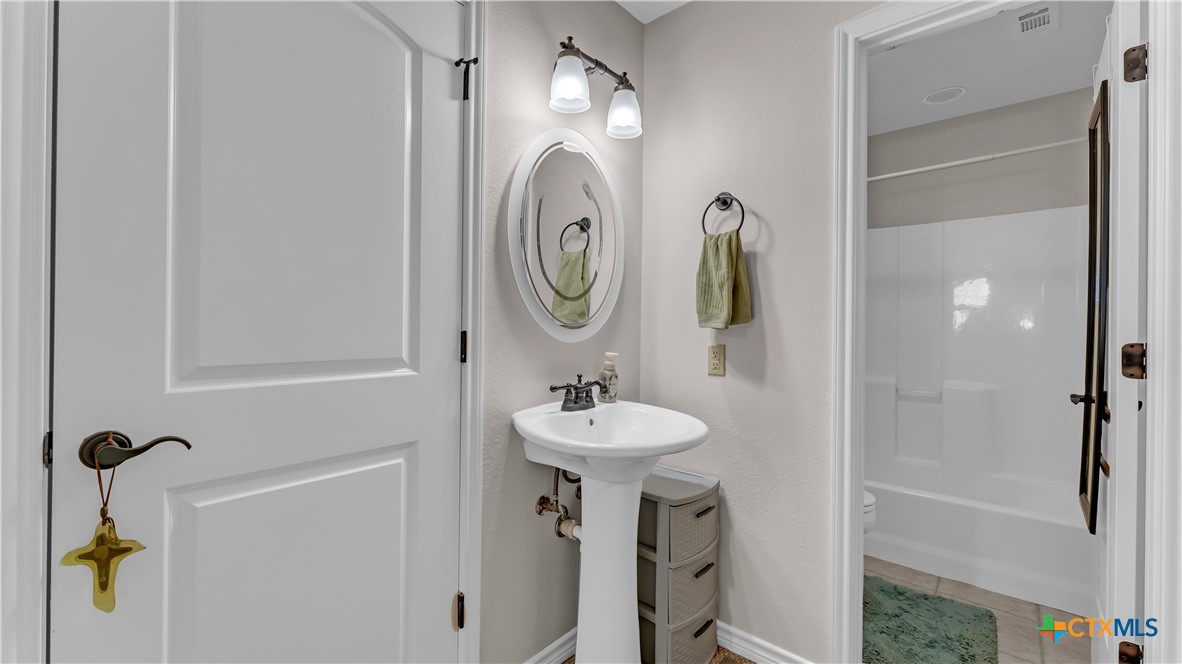 306 Alexander Avenue Burnet, TX 78611 - Photo 18 of 38 a bathroom with a sink mirror and tub