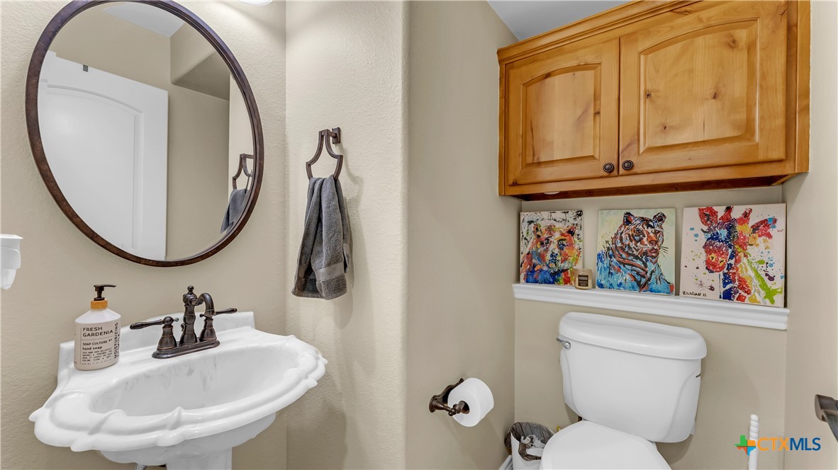 306 Alexander Avenue Burnet, TX 78611 - Photo 22 of 38 a bathroom with a toilet a sink and a mirror