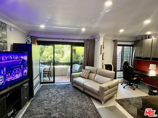 a room with stainless steel appliances a table and chairs