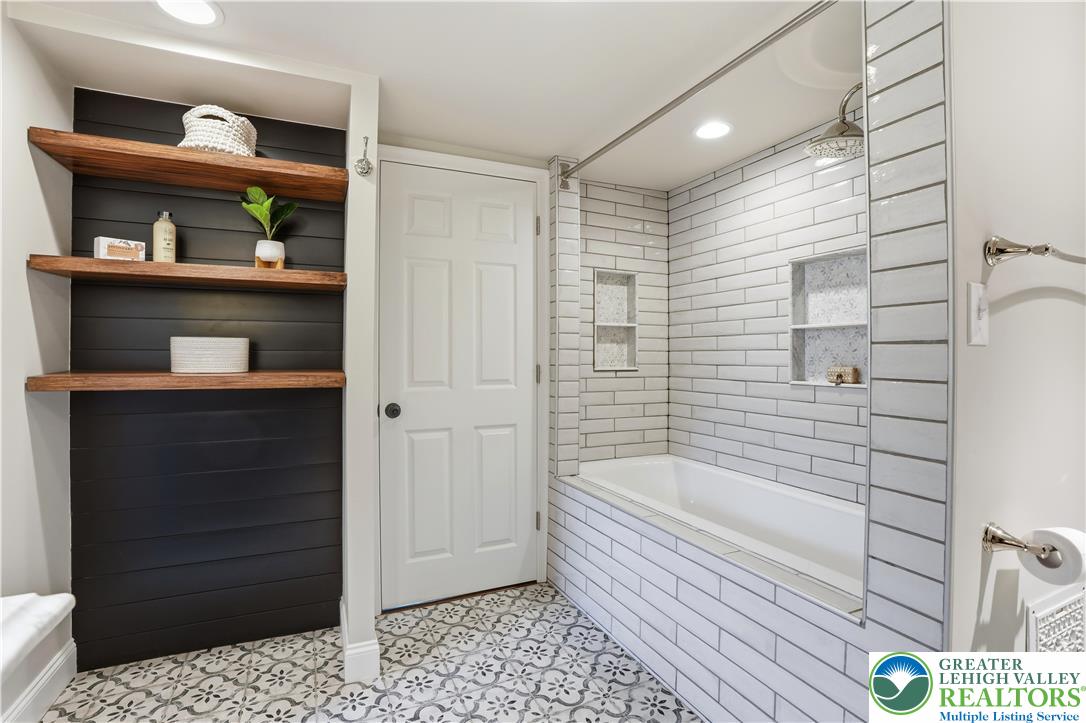 2014 Linden Street Bethlehem, PA 18017 - Photo 43 of 85 A well-lit bathroom features elegant tile flooring and a tub with a subway tile surround.