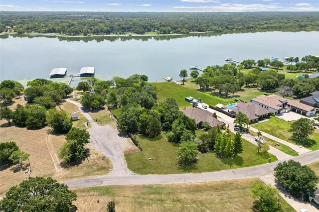 an aerial view of residential houses with outdoor space and lake view