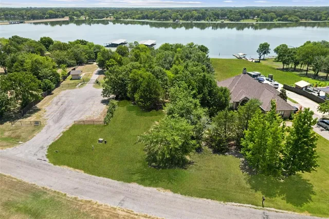 an aerial view of a house with a yard lake lake house and tree in back
