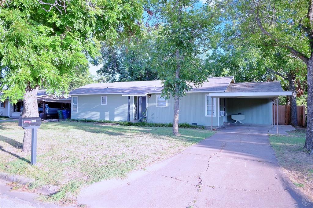 a view of a house with a yard and large tree