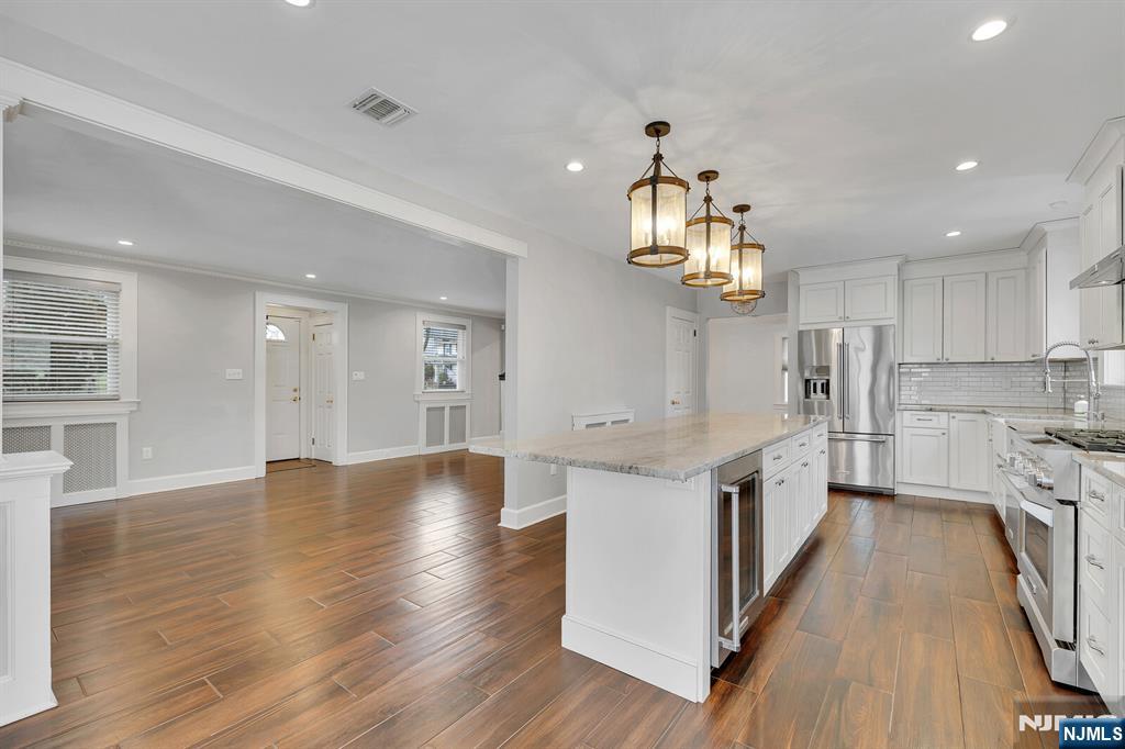 346 Carmita Avenue Rutherford, NJ 07070 - Photo 11 of 47 a kitchen with granite countertop a stove top oven a sink dishwasher and a refrigerator with wooden floor