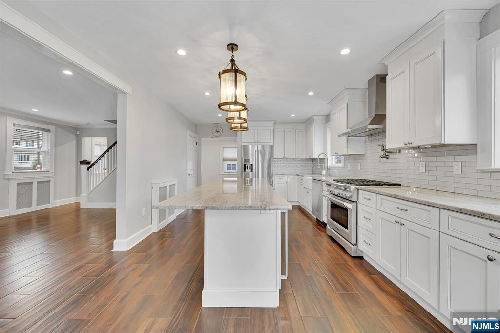 346 Carmita Avenue Rutherford, NJ 07070 - Photo 12 of 47 a large kitchen with stainless steel appliances kitchen island a large counter top and wooden floors