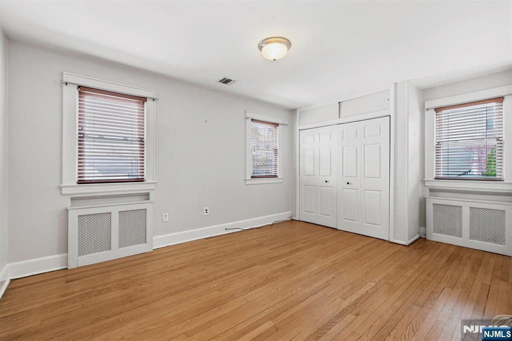 346 Carmita Avenue Rutherford, NJ 07070 - Photo 26 of 47 an empty room with wooden floor and windows