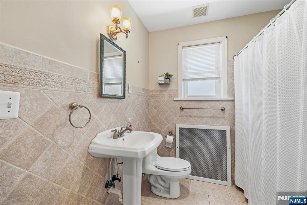 346 Carmita Avenue Rutherford, NJ 07070 - Photo 28 of 47 a bathroom with a sink a toilet and mirror