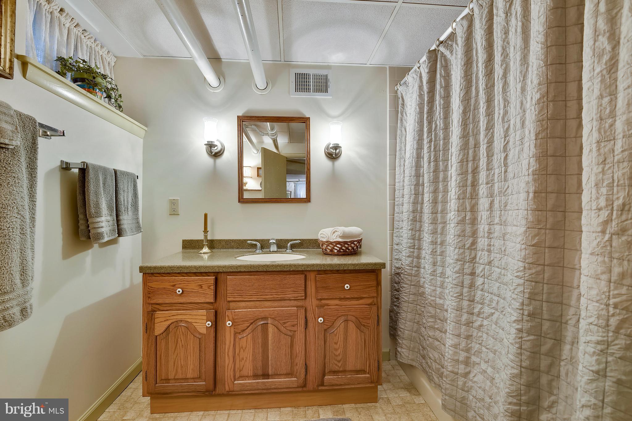 708 Stoneleigh Road Baltimore, MD 21212 - Photo 49 of 61 a bathroom with a granite countertop sink a mirror and a shower