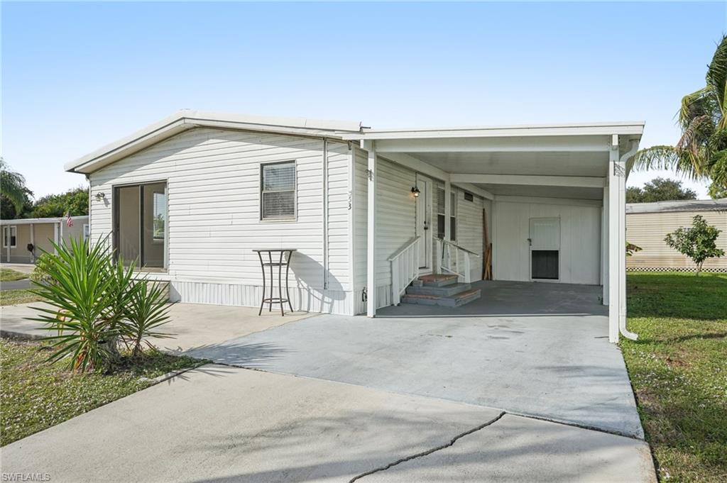 a view of a house with a yard and potted plants