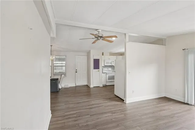 an empty room with wooden floor and a ceiling fan