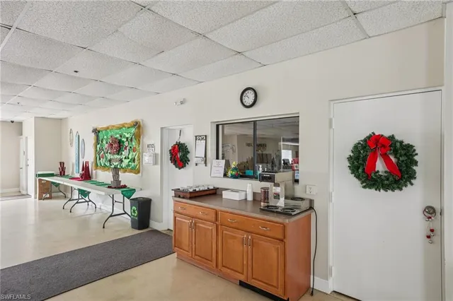 a living room with kitchen island furniture a flat screen tv and a sink