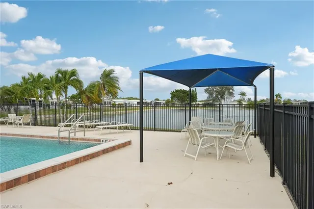 a view of a lake with a table and chairs under an umbrella