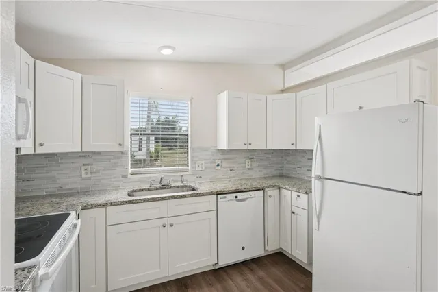 a kitchen with a sink cabinets stainless steel appliances and a window