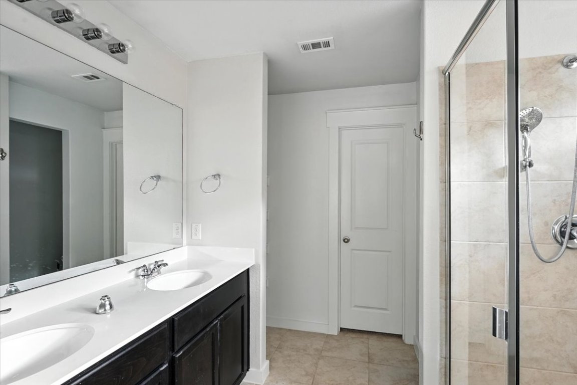 305 Old Trinity Way Georgetown, TX 78628 - Photo 14 of 23 a bathroom with a double vanity sink mirror and shower