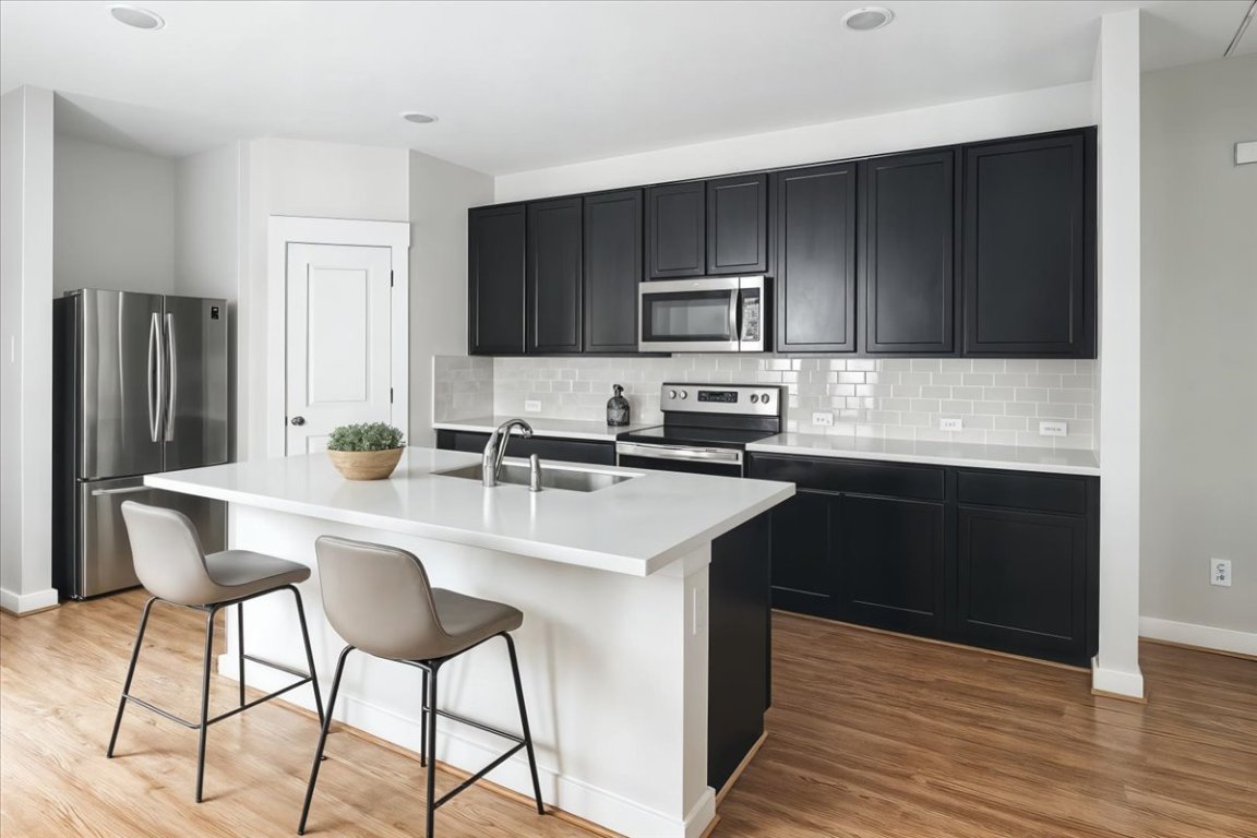 305 Old Trinity Way Georgetown, TX 78628 - Photo 7 of 23 a kitchen with appliances cabinets a sink and a counter space