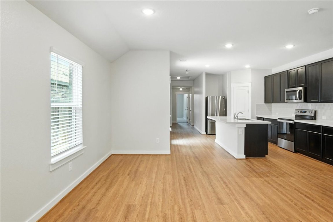 305 Old Trinity Way Georgetown, TX 78628 - Photo 8 of 23 a large kitchen with stainless steel appliances wooden floors and large window