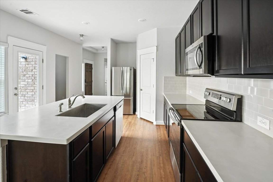 305 Old Trinity Way Georgetown, TX 78628 - Photo 9 of 23 a kitchen with stainless steel appliances granite countertop a sink and a stove