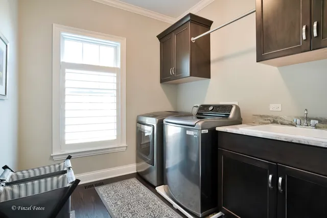 a utility room with a window a sink and a refrigerator