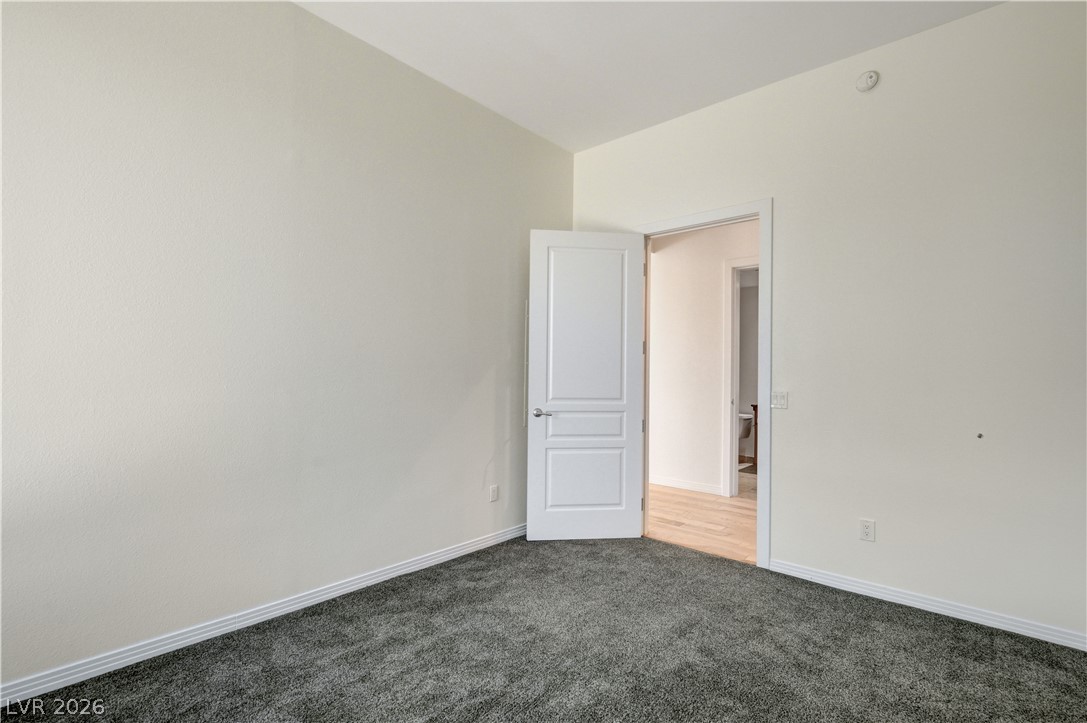 360 East Desert Inn Road, Unit 402 Las Vegas, NV 89109 - Photo 35 of 40 A well-proportioned bedroom with new carpet and classic white trim, ready for personalization.